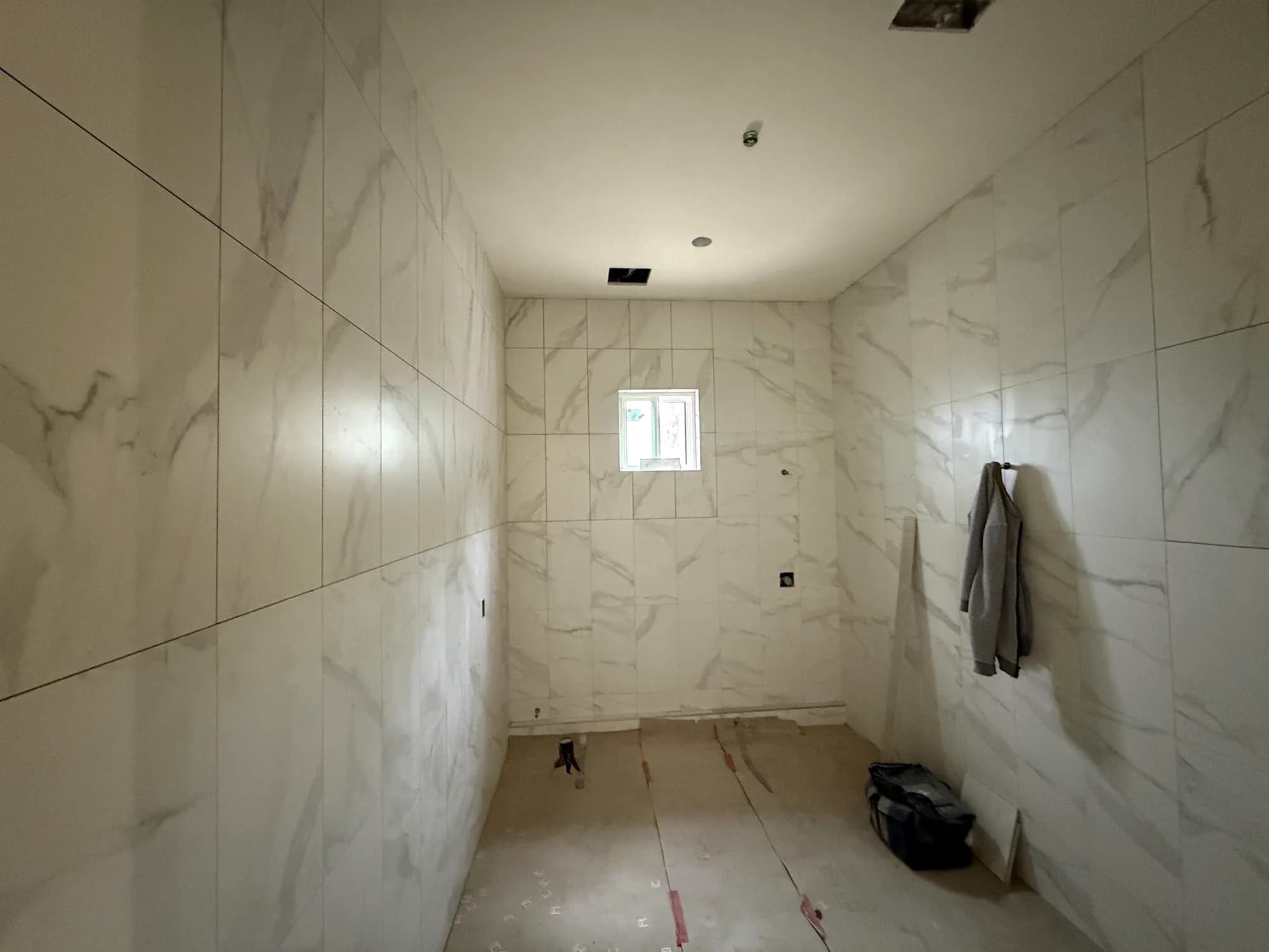 Full-height marble to the shower wall