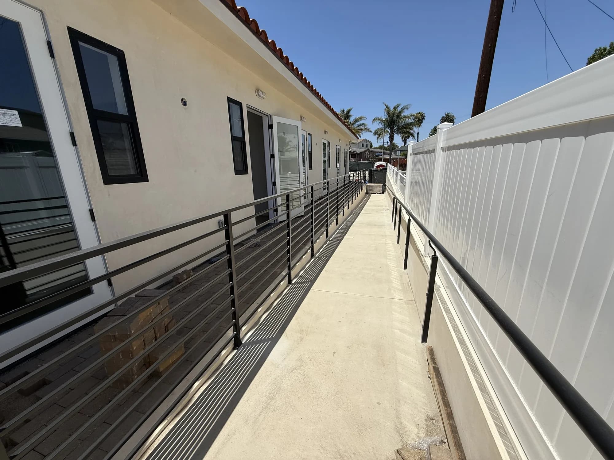 Finished walkway and railings along a completed multi-unit building by APW Builders
